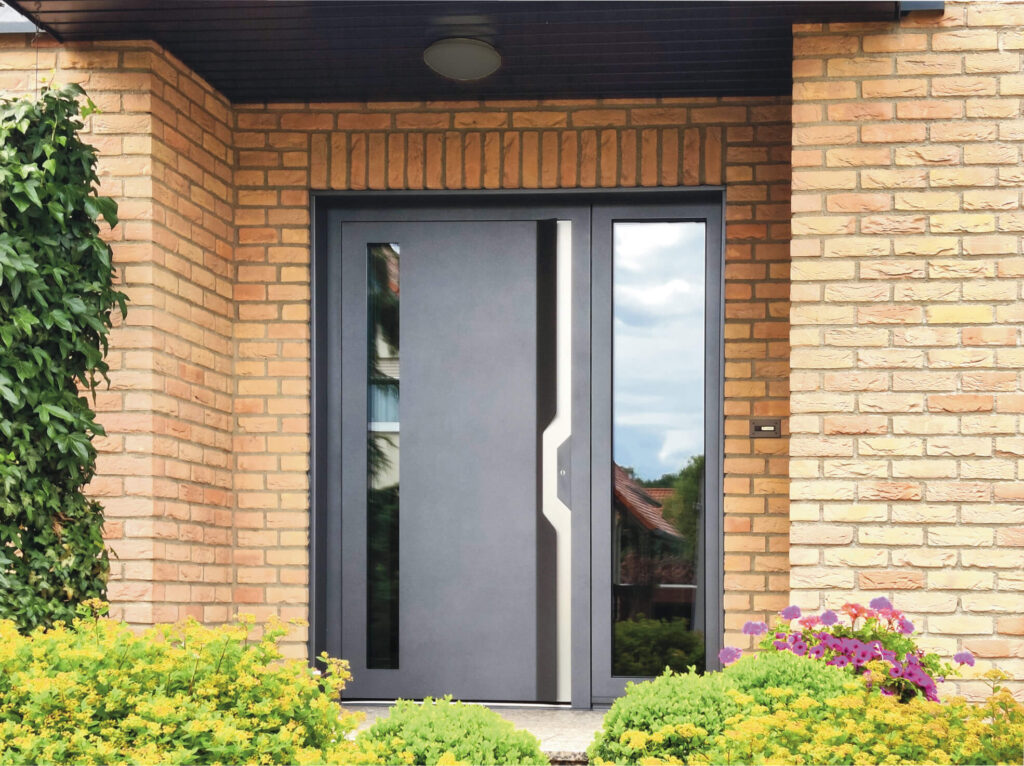 Einbruchsichere Haustür in Anthrazit mit Glas-Seitenteil und modernem Design an Klinkerfassade mit Vorgarten